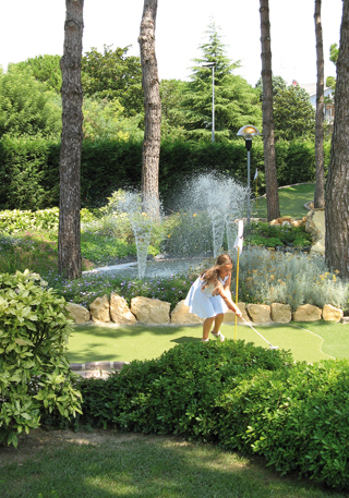Girl on golf fairway in front of a fountain